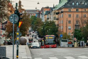 Stadsvy från Södermalm med röda bussar och klassisk arkitektur under naturligt dagsljus.