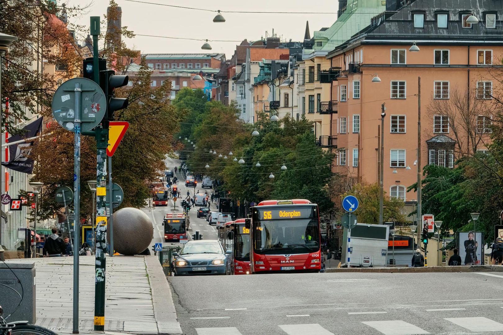Stadsvy från Södermalm med röda bussar och klassisk arkitektur under naturligt dagsljus.